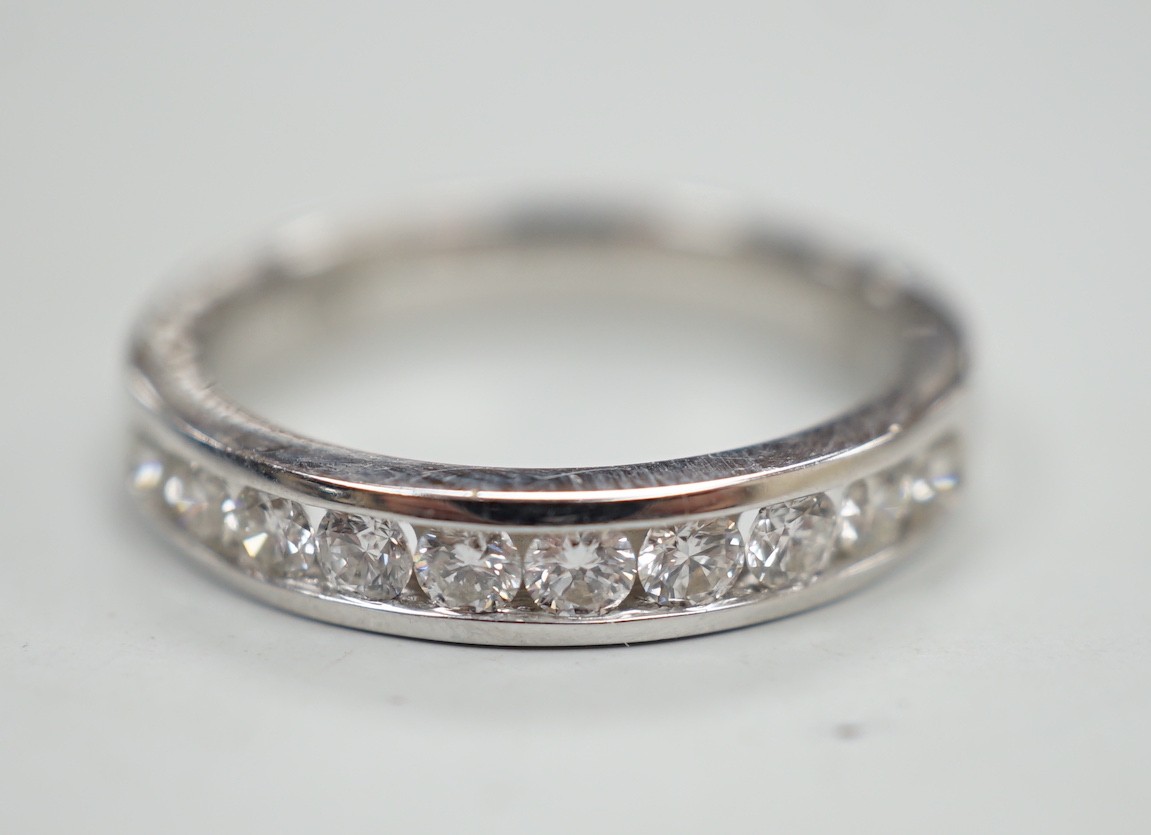A modern 18k white metal and ten stone channel set diamond half eternity ring, size L/M, gross weight 4.1 grams.